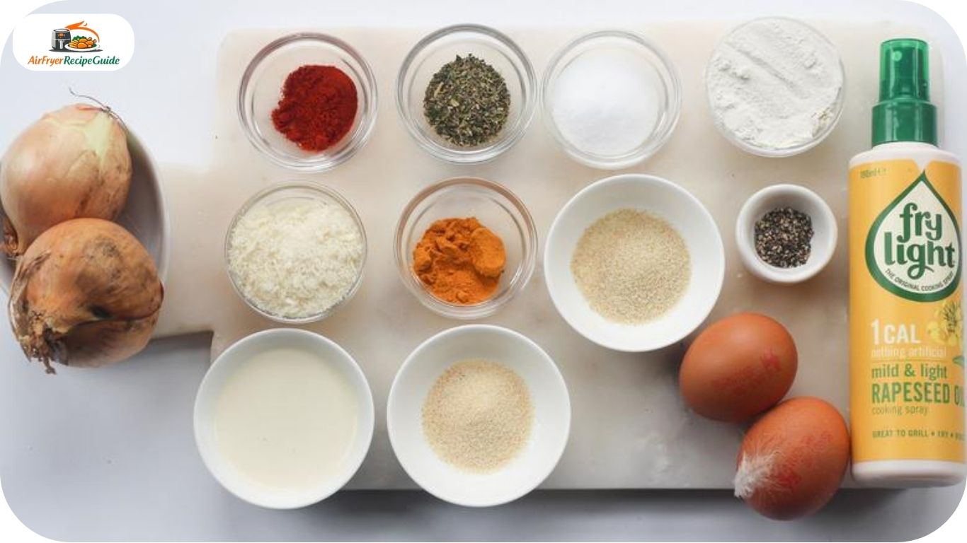 Raw onion rings panko breadcrumbs eggs flour and spices arranged on countertop