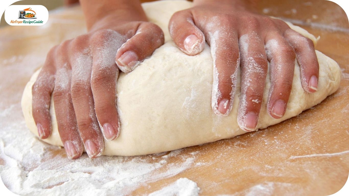 Hands kneading homemade bread dough on wooden table