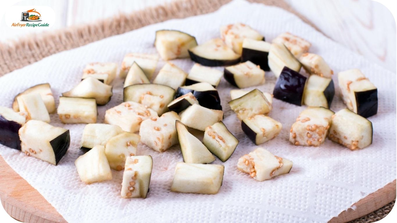 Salted eggplant cubes resting on paper towels before air frying